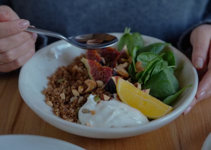 A vibrant brunch bowl with fruit, greens, and nuts for a nutritious meal.