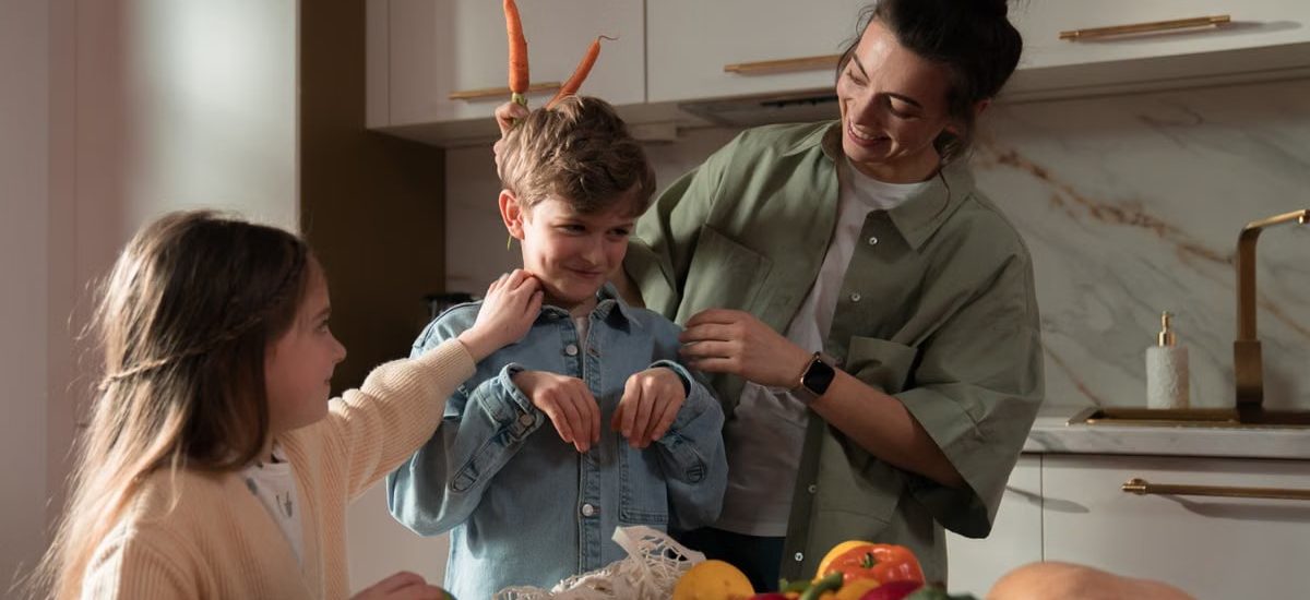 Mother and children have fun unpacking vegetables in the kitchen.