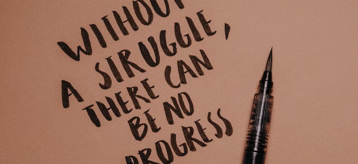 Handwritten motivational quote using a brush pen on a textured background for inspiration.