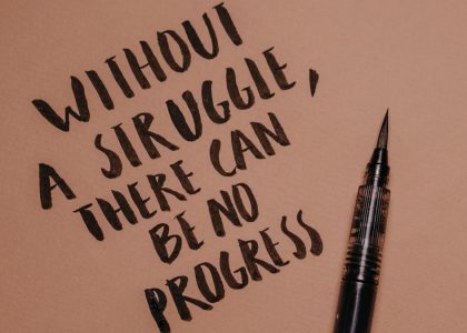 Handwritten motivational quote using a brush pen on a textured background for inspiration.